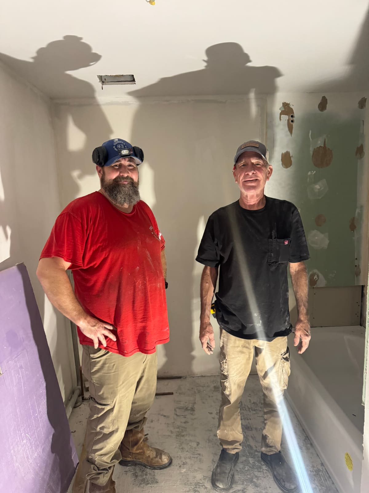Two Danny's Heating and Air technicians standing together on a job site