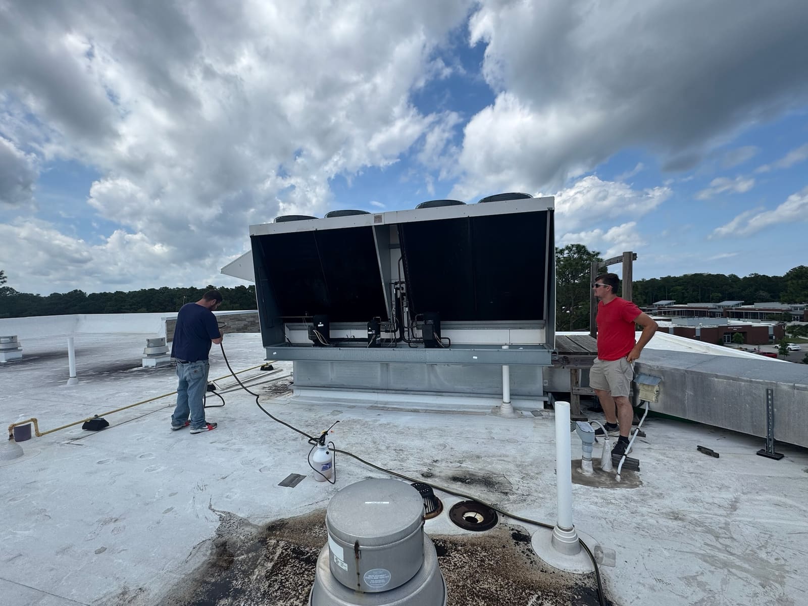 Two Danny's technicians servicing a commercial rooftop chiller unit